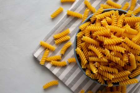 Dry Fusilli Pasta in a Bowl, top view. Flat lay, overhead, from above. Copy space.の写真素材