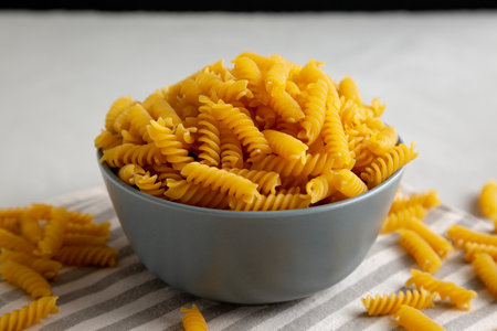 Dry Fusilli Pasta in a Bowl, low angle view. Close-up.の写真素材