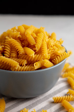 Dry Fusilli Pasta in a Bowl, low angle view. Close-up.の写真素材