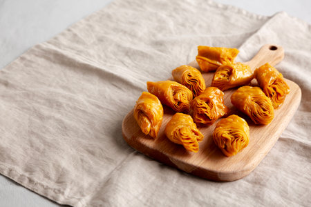 Sweet Homemade Turkish Baklava with Honey on a Wooden Board, side view. Copy space.