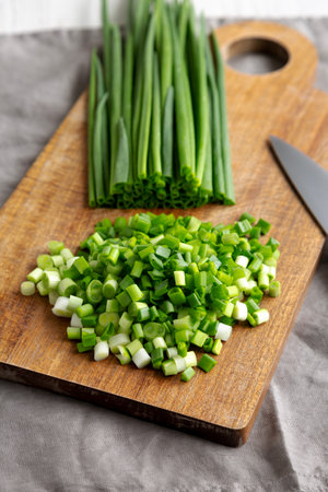 Organic Cut Green Onion Scallions on a Wooden Board, side view.