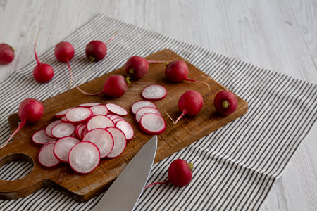 Raw Red Radish Slices on a Cutting Board, side view. Copy space.の写真素材