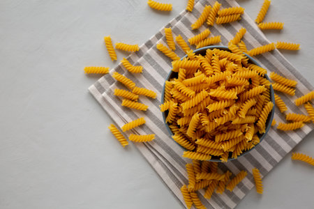 Dry Fusilli Pasta in a Bowl, top view. Flat lay, overhead, from above.