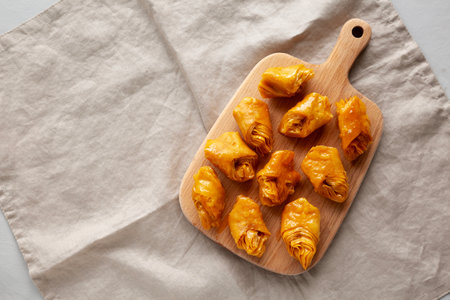 Sweet Homemade Turkish Baklava with Honey on a Wooden Board, top view. Copy space.