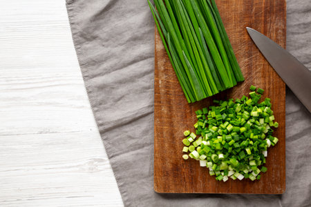 Organic Cut Green Onion Scallions on a Wooden Board, top view. Copy space.