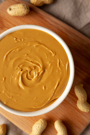 Organic Peanut Butter in a Bowl, top view. Flat lay, overhead.