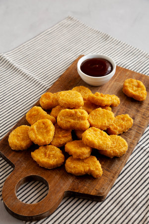 Organic Fried Chicken Nuggets on a wooden board, side view. Copy space.の写真素材