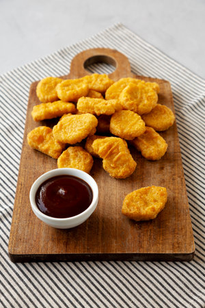 Organic Fried Chicken Nuggets on a wooden board, side view.の写真素材