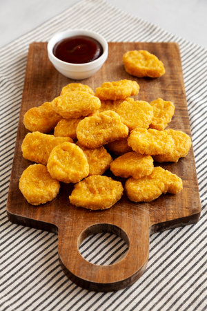Organic Fried Chicken Nuggets on a wooden board, side view.の写真素材