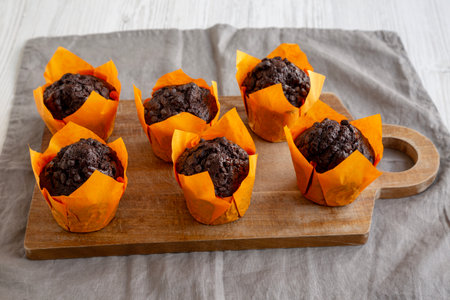 Homemade Chocolate Chip Muffins on a wooden board, side view.の写真素材