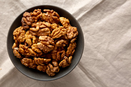 Raw Walnut Halfs in a Bowl, top view. Flat lay, overhead. Copy space.の写真素材