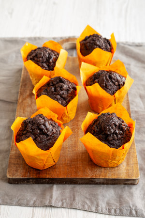 Homemade Chocolate Chip Muffins on a wooden board, side view.の写真素材
