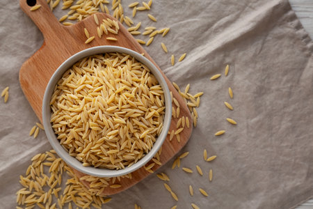 Organic Dried Orzo Pasta in a Bowl, top view. Space for text.の写真素材