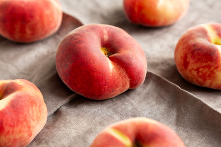Fresh juicy ripe flat peaches, side view.の写真素材