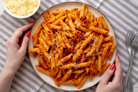 Female hands hold a plate with homemade Pasta Bolognese with Cheese, top view.の写真素材
