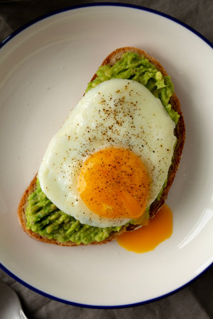 Homemade Avocado Toast with Egg on a Plate, top view. Close-up.