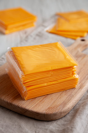 Stack of American Cheese Slices in Wrappers, side view.