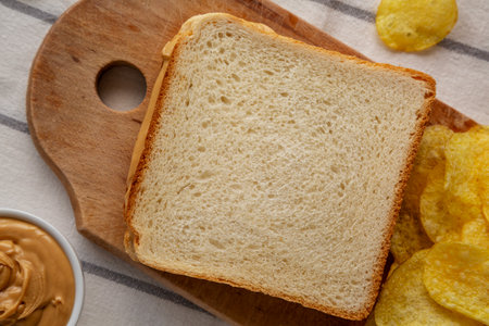 Homemade American Peanut Butter Sandwich and Potato Chips, top view.