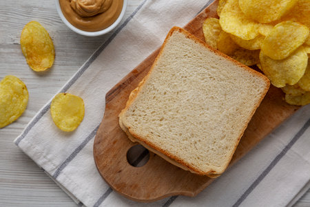 Homemade American Peanut Butter Sandwich and Potato Chips, top view.