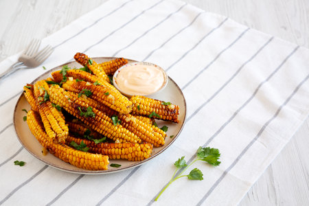 Homemade Spicy Corn Ribs with Mayo on a Plate, side view. Copy space.