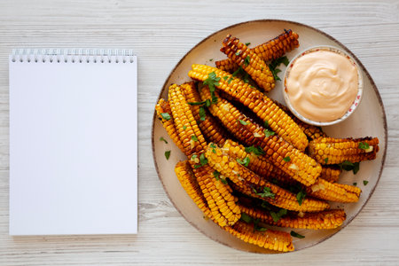 Homemade Spicy Corn Ribs with Mayo on a Plate, blank notepad, top view.の写真素材