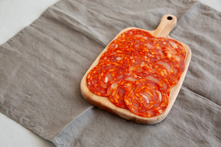 Cold Meat Chorizo Slices on a Wooden Board, side view. Copy space.の写真素材