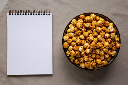 Homemade Caramel Pop Corn in a Bowl, blank notepad, top view.の写真素材