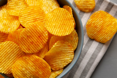 Crinkle Potato Chips with Chorizo Sausages and Onions Flavor in a Bowl, top view.の写真素材