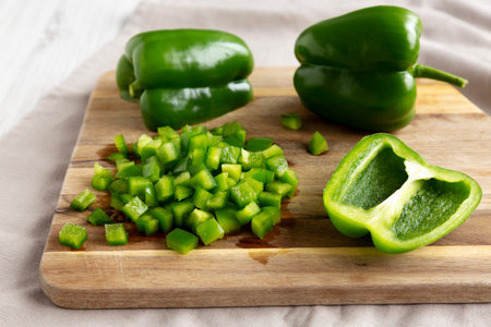 Organic Chopped Green Bell Peppers arranged on a Cutting Board, side view.の写真素材