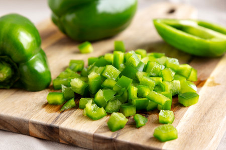 Organic Chopped Green Bell Peppers arranged on a Cutting Board, side view. Close-up.の写真素材