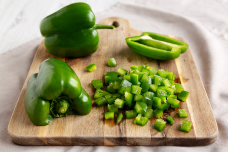 Organic Chopped Green Bell Peppers arranged on a Cutting Board, side view.の写真素材