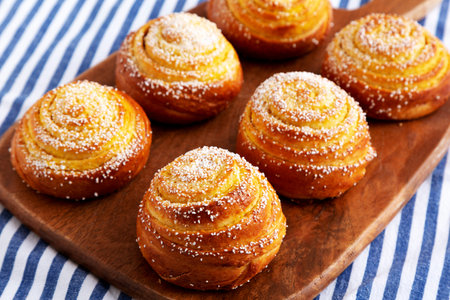 Homemade Lemon Buns on a wooden board, side view.