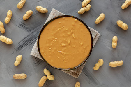 Creamy Peanut Butter in a Bowl, top view. Flat lay, overhead.