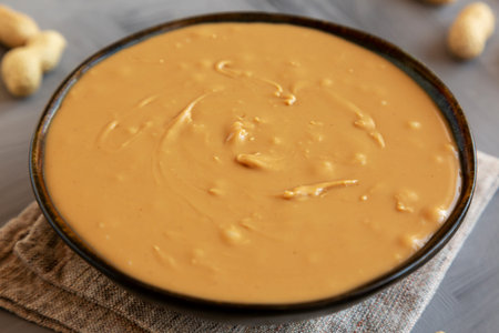 Creamy Peanut Butter in a Bowl, side view. Close-up.