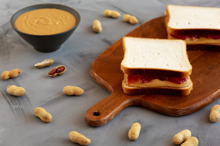 Homemade Peanut Butter and Jelly Sandwich on a Wooden Board, side view.