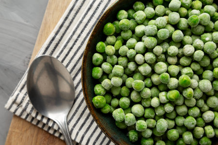 Organic Frozen Green Peas in a Bowl, top view. Overhead, from above.