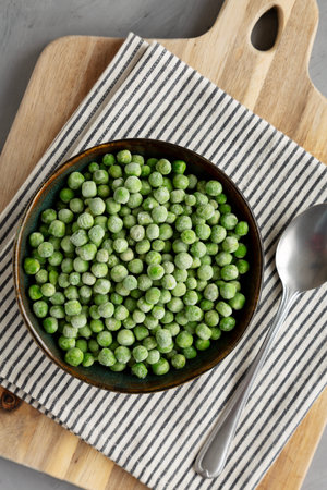 Organic Frozen Green Peas in a Bowl, top view. Overhead, from above.