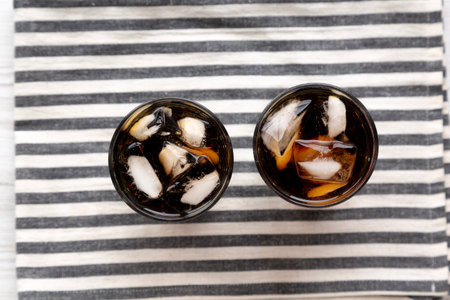 Refreshing Dark Cola with Ice Cubes in Glasses, top view.
