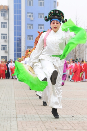 LUANNAN COUNTY OF HEBEI PROVINCE - FEBRUARY 21  During the Chinese Lunar New Year, people wear colorful clothes, yangko dance performances in the street, on February 21, 2013, Luannan County, Hebei Province, China のeditorial素材