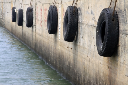 tire fixed to the wall in a wharfの写真素材