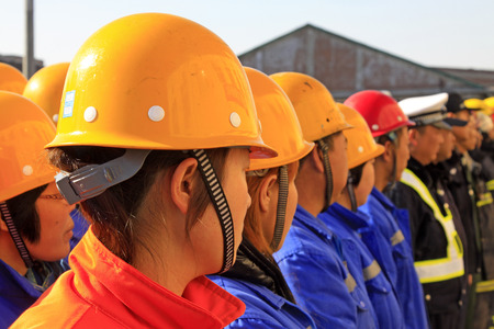 TANGSHAN CITY - NOVEMBER 20: Putting yellows helmet queue in a factory on november 20, 2013, tangshan city, hebei province, China. のeditorial素材
