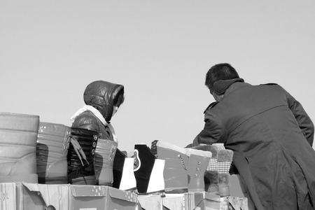 LUANNAN COUNTY - JANUARY 28: The customer and vendor in bargaining, before a footwear stalls, on january 28, 2014, Luannan county, Hebei province, China. のeditorial素材