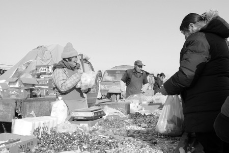 LUANNAN COUNTY - JANUARY 28: The customer and vendor in bargaining, before a candy stalls, on...