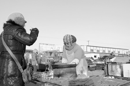 LUANNAN COUNTY - JANUARY 28: The customer and vendor in bargaining, before a cooked food stalls, on january 28, 2014, Luannan county, Hebei province, China. のeditorial素材