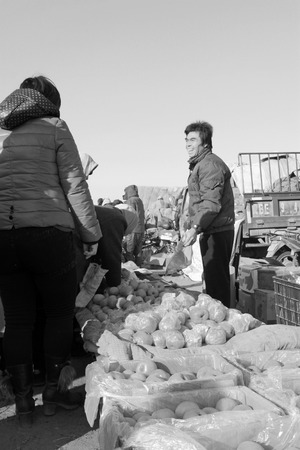 LUANNAN COUNTY - JANUARY 28: The customer and vendor in bargaining, before a fruit stalls, on january 28, 2014, Luannan county, Hebei province, China. のeditorial素材