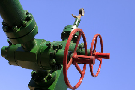 green petroleum machinery and red handwheel, closeup of photo