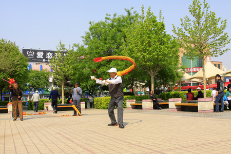 LUANNAN COUNTY, CHINA - APRIL 29: An old man was shaking diabolo on the Square, on april 29, 2014, Luannan county, Hebei province, China  のeditorial素材