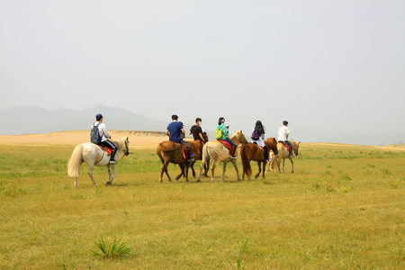 WULANBUTONG GRASSLAND - JULY 19: Travelers on horseback in the WuLanBuTong grassland on July 19, 2014, Inner Mongolia autonomous region, China. のeditorial素材