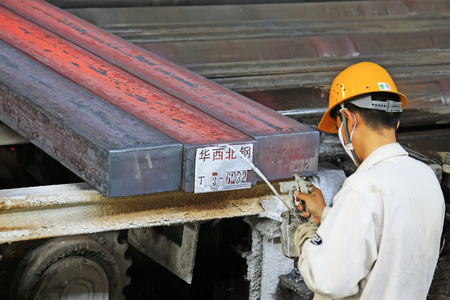 TANGSHAN - JUNE 18: a worker spraying code for steel ingot in iron and steel co., on June 18, 2014, Tangshan city, Hebei Province, Chinaのeditorial素材