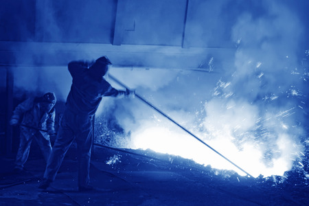 iron works blast furnace taphole spewing molten iron, closeup of photoの写真素材